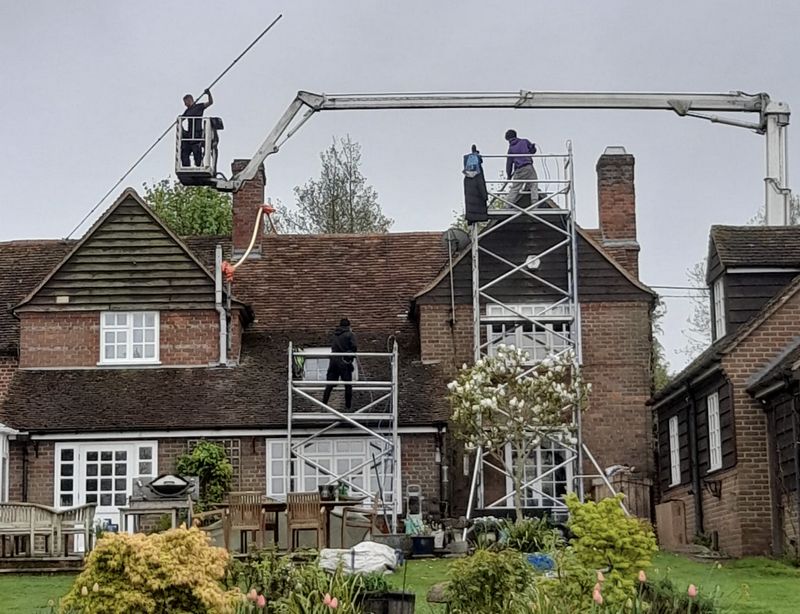The Moss Cleaners using cherry picker and scaffolding to clean roof safely and professionally in Warlingham, Surrey
